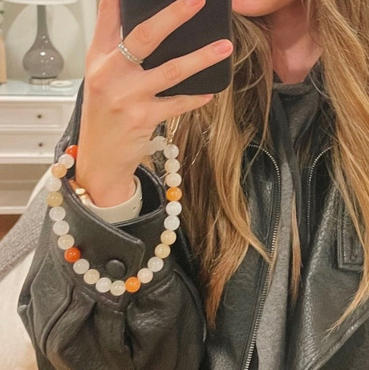 Person wearing a beaded bracelet with a neutral background